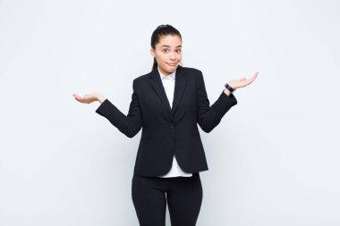 Genç ve güzel bir kadın şaşkın ve şaşkın hissediyor, şüpheci, farklı seçenekleri tartıyor ya da komik ifade işi konseptiyle seçiyor.