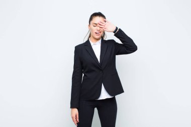 Genç ve güzel bir kadın stresli görünüyor, yorgun ve hayal kırıklığına uğramış, alnından ter damlayan, umutsuz ve tükenmiş iş konsepti hisseden.