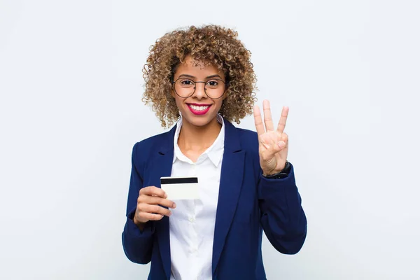 アフリカ系アメリカ人の若い女性は笑顔で親しみやすく 前方に手札で3番目または3番目の数字を示し クレジットカードでカウントダウンします — ストック写真