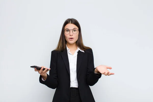 年轻漂亮的女人感到极度震惊 焦虑和恐慌 带着紧张而可怕的表情和手机 — 图库照片