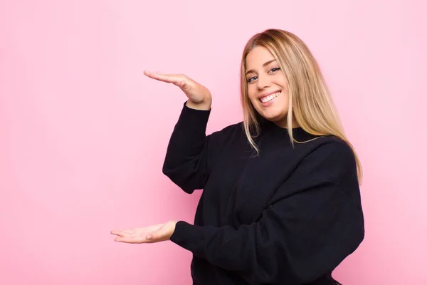 Joven Rubia Sonriendo Sintiéndose Feliz Positiva Satisfecha Sosteniendo Mostrando Objeto — Foto de Stock