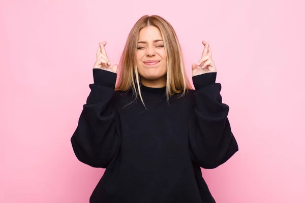 Joven Rubia Sonriendo Ansiosamente Cruzando Ambos Dedos Sintiéndose Preocupada Deseando — Foto de Stock