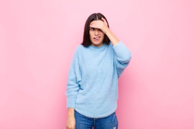 Genç ve güzel bir kadın unutulmuş bir süre için panikliyor, stresli hissediyor, pembe duvara karşı bir karmaşayı ya da hatayı örtbas etmek zorunda kalıyor.