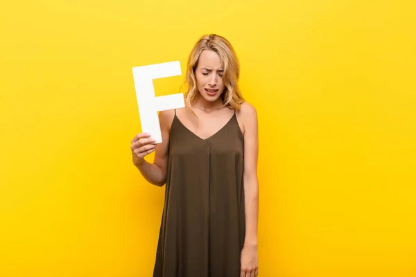 Młoda Blondynka Smutna Przygnębiona Nieszczęśliwa Trzymająca Literę Alfabetu Aby Utworzyć — Zdjęcie stockowe