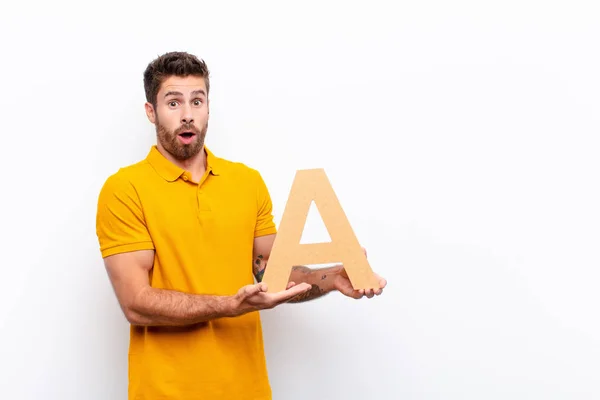 Young Handsome Man Surprised Shocked Amazed Holding Letter Alphabet Form — 스톡 사진