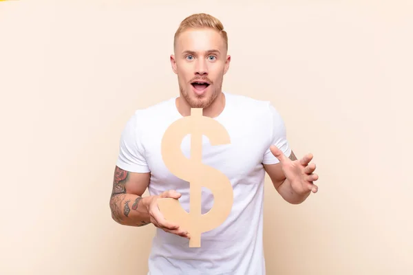 Young Blonde Man Surprised Shocked Amazed Holding Symbol Form Word — Stock Photo, Image