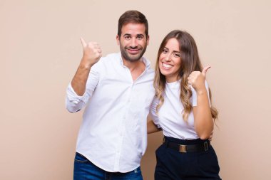 Genç ve güzel bir çift bej düz duvara karşı