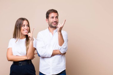 Genç ve güzel bir çift bej düz duvara karşı