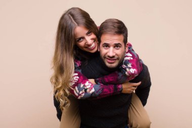 Genç ve güzel bir çift bej düz duvara karşı