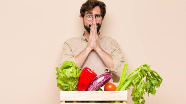 Yeşil bakkal endişeli, umutlu ve dindar hissediyor. Avuçlarına bastırılmış, af dileyen sadık bir şekilde dua ediyor.