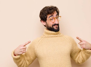 Genç havalı adam gururlu, kibirli, mutlu, şaşırmış ve tatmin olmuş görünüyor, kendini göstererek, düz duvara karşı kazanan gibi hissediyor.
