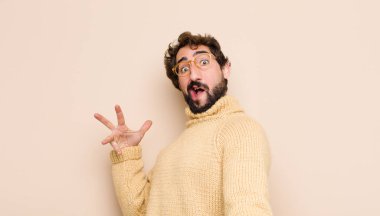 Genç havalı adam mutlu, kibirli, gururlu ve kendinden memnun görünüyor. Düz duvara karşı kendini bir numara gibi hissediyor.