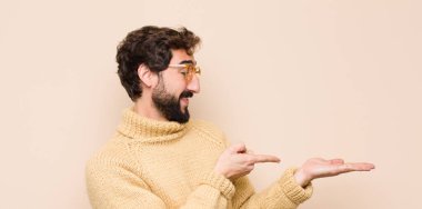 Genç, havalı bir adam gülümsüyor, mutlu, kaygısız ve tatmin olmuş hissediyor. Fotokopi odasının kenarındaki düz duvara karşı konsepte ya da fikre işaret ediyor.