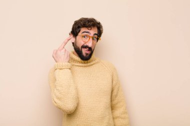 Genç, havalı bir adam kafası karışık ve şaşkın hissediyor. Deli, deli ya da düz duvara karşı aklını kaçırmış olduğunu gösteriyor.