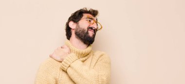 Genç havalı adam yorgun, stresli, endişeli, hayal kırıklığına uğramış ve depresif hissediyor, sırtı ya da boynu düz duvara dayanmış acı çekiyor.