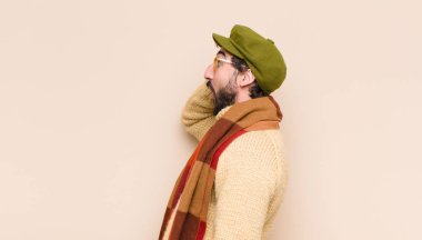 Genç, havalı sakallı adam heyecanlı ve şaşırmış görünüyor, iki eli başında, kendini şanslı bir kazanan gibi hissediyor.