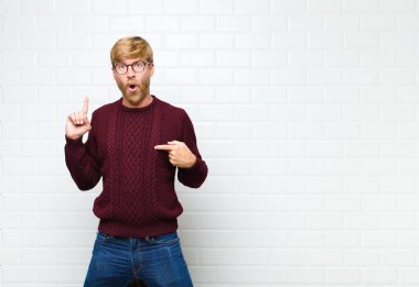 Genç sarışın adam kendini gururlu ve şaşırmış hissediyor. Kendine güveni tam. Kendini başarılı bir birinci şahıs gibi hissediyor.