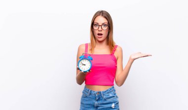 Kızıl saçlı, güzel bir kadın çalar saat tutuyor ve bir konsept anlatıyor.