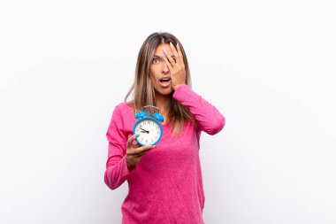 Genç, güzel bir kadın şok olmuş, korkmuş ya da dehşete düşmüş gibi görünüyor. Yüzü elle örtülmüş ve elinde çalar saatle parmaklarının arasından bakıyor..