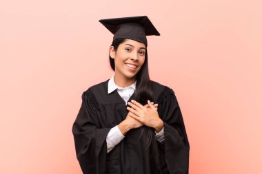 Genç Latin kız öğrenci romantik, mutlu ve aşık, neşeyle gülümseyen ve kalbe yakın el ele tutuşan