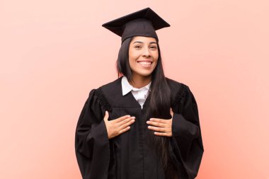 Genç Latin kız öğrenci mutlu, şaşırmış, gururlu ve heyecanlı görünüyor.