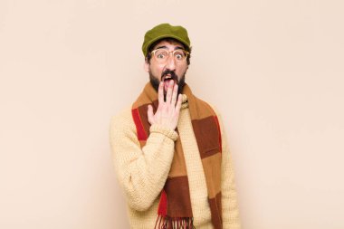 Genç, havalı sakallı adam sabahın erken saatlerinde uykulu, yorgun ve sıkkın bir şekilde esniyor.