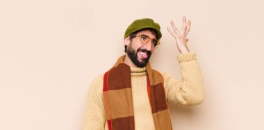 Aptal bir hata yaptıktan ya da hatırladıktan sonra kendini aptal gibi hissederek avuçtan avuca kadar yükselen sakallı genç adam.