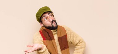 Genç sakallı adam şaşkın ve şaşkın hissediyor, doğru cevap ya da karardan emin değil, bir seçim yapmaya çalışıyor.