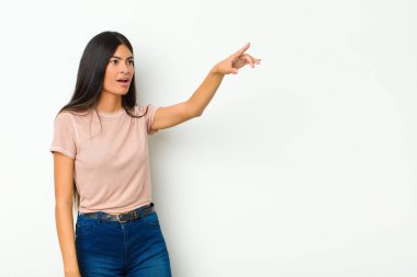 Genç, güzel, Latin bir kadın şok olmuş ve şaşırmış hissediyor. Şaşırmış ve yukarı bakıyor. Şaşırmış, ağzı açık bir şekilde duvara bakıyor.