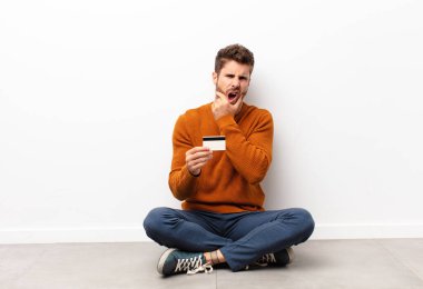 Ağzı ve gözleri açık ve elleri çenesinde, nahoş bir şekilde şokta, ne diyor ya da vay be