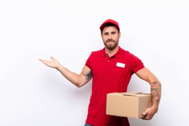 Gururla ve özgüvenle gülümsüyor, mutlu ve tatmin olmuş hissediyor ve fotokopi alanında bir konsept gösteriyor. dağıtım konsepti