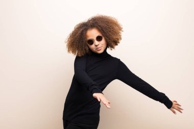 Afrikalı Amerikalı küçük kız düz duvara yaslanmış. cool konsept