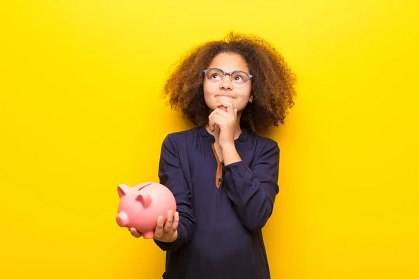 Afrikaans Amerikaans Meisje Tegen Platte Muur Met Een Spaarvarken Bank — Stockfoto