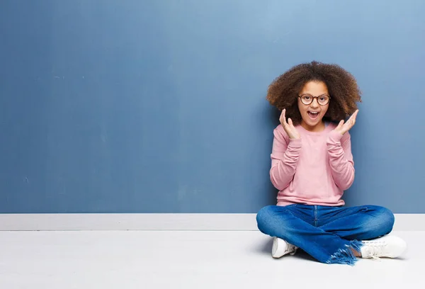 一个意想不到的惊喜坐在地板上 使美国黑人小女孩感到震惊 惊奇和快乐 — 图库照片