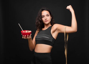 Genç ve güzel bir kadın sağlıklı bir kase yiyor.