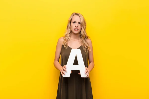 Jovem Loira Mulher Confusa Duvidosa Pensando Segurando Letra Alfabeto Para — Fotografia de Stock