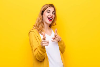 Genç, güzel, sarışın bir kadın kendini mutlu, sakin, rahat ve başarılı hissediyor. Kameraya bakıyor, sarı duvara karşı seni seçiyor.