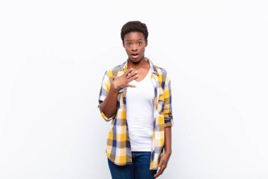 Genç ve güzel siyahi kadın şaşkın, şaşkın ve şaşırmış, elleri göğsünde ve ağzı açık, kim olduğumu söylüyor, ben?