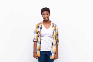 Genç, güzel, siyah kadın kafası karışmış ve kafası karışmış görünüyor. Bir sorunu çözmeye çalışıyor ya da düşünüyor.