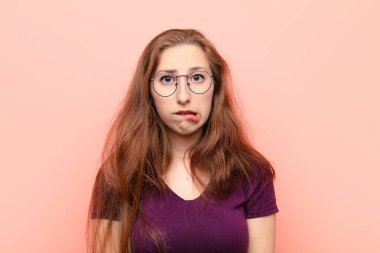 Genç sarışın kadın şaşkın ve şaşkın görünüyor. Sinirli bir hareketle dudağını ısırıyor. Sorunun cevabını bilmiyor.