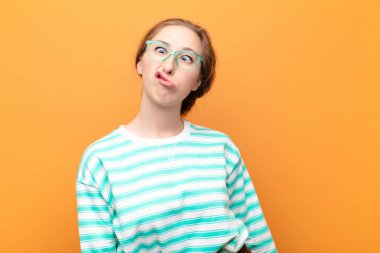 Genç sarışın kadın şapşal ve komik görünüyor. Şaşı bakışlı, şakacı ve şakacı.