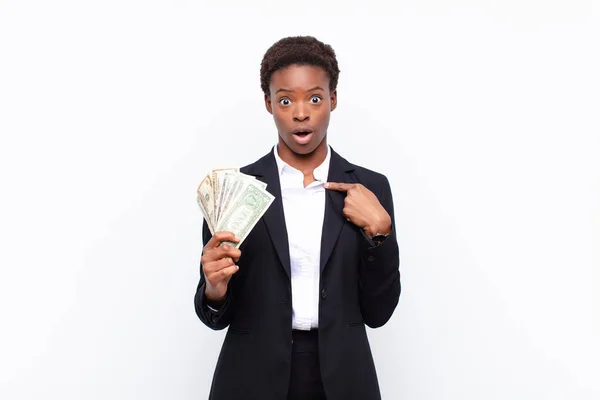若い黒人女性はショックを受けて口を大きく開けて銀行券を手にしました — ストック写真