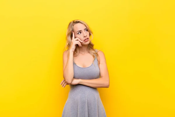 Mujer Rubia Joven Con Una Mirada Concentrada Preguntándose Con Una — Foto de Stock