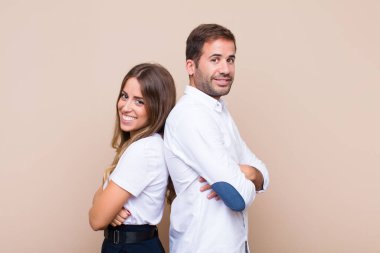 Genç ve güzel bir çift bej düz duvara karşı