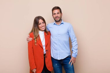 Genç ve güzel bir çift bej düz duvara karşı