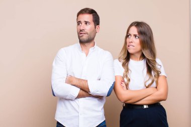 Genç ve güzel bir çift bej düz duvara karşı