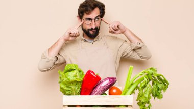 Yeşil bakkal adam konsantre görünüyor ve bir fikir üzerinde çok düşünüyor, bir meydan okumaya ya da soruna bir çözüm hayal ediyor.