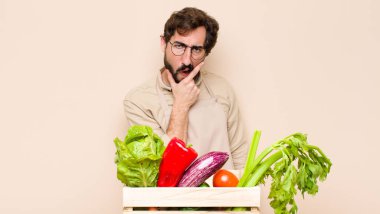 Ağzı ve gözleri açık, eli çenesinde olan yeşil bakkal adam, kötü bir şok geçiriyor, ne diyor ya da vay canına.