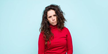 Genç, güzel bir kadın üzgün ve mızmızlanıyor. Mutsuz bir bakışla, ağlarken mavi duvara karşı olumsuz ve hayal kırıklığına uğramış bir tavırla.