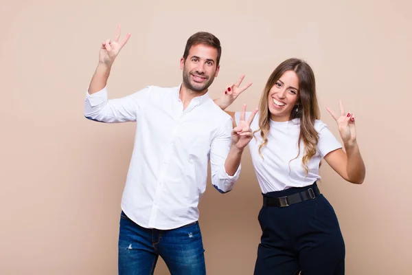 Joven Bonita Pareja Contra Pared Plana Beige — Foto de Stock